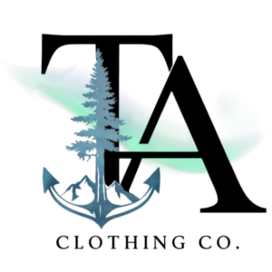 Tamarack Atlantic Clothing Co. official logo, 300x300px, transparent. A tamarack tree that is rooted in a ship anchor. Mountain peak elements can be seen behind the anchor. Large, majestic letters "TA" tower over the tamarack tree as northern lights whisp across the logo.